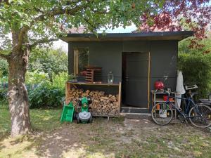 una pequeña casa verde con una pila de leña en Schaferwagen en Kassel