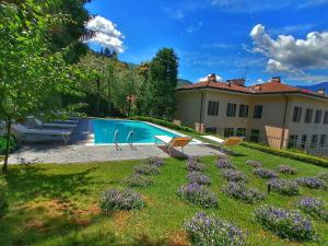 un patio con piscina y una casa en Domus Plinii 1792 Suites, en Faggeto Lario 