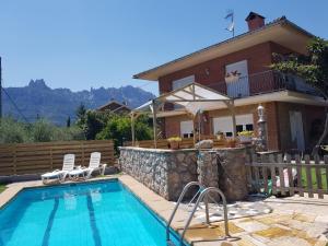 a house with a swimming pool in front of a house at Apartament Vall de Montserrat in Castellbell i Vilar