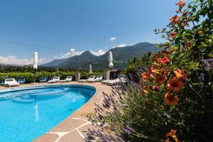 a swimming pool with chairs and mountains in the background at Hotel Residence Martha in Lana