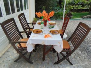 a table with a white table cloth and orange flowers on it at Casa Rebelo in Cossourado