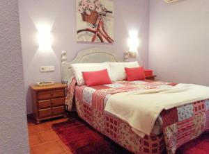1 dormitorio con 1 cama grande con almohadas rojas en Hostal Mizmaya, en Hoznayo