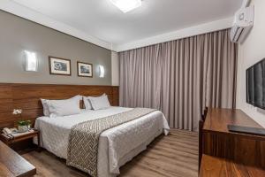 a hotel room with a bed and a flat screen tv at Hotel Bahia do Sol in Salvador