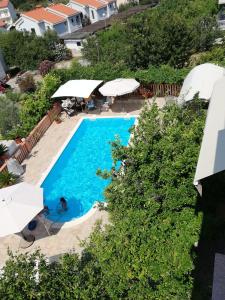 una vista aérea de una piscina con sombrillas en Apartments Bene, en Rab