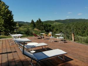 a group of tables and chairs on a wooden deck at B&B CASAGRANDE in Quercegrossa