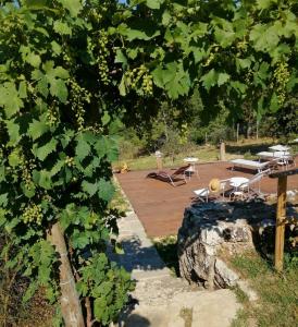 una terrazza in legno con tavoli e sedie in un cortile di B&B CASAGRANDE a Quercegrossa