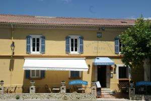 a building with a white awning in front of it at Logis Grand Hotel Bain in Comps-sur-Artuby