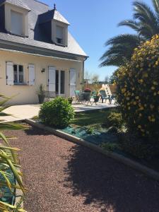 a house with a garden in front of it at Côté jardin des Charmilles in Quettehou