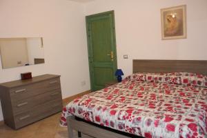 a bedroom with a bed and a dresser and a green door at Appartamento 5 Vista Panoramica in Cala Gonone