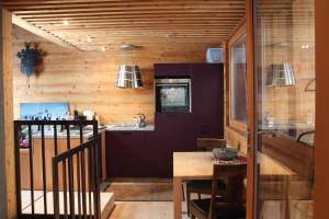 a kitchen with wooden walls and a wooden table at Nid d'Amour, le Nain. in Albinen