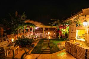 a house with a patio at night with lights at Sari Gelin Alacati Hotel in Alaçatı