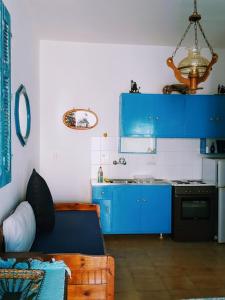 uma cozinha com armários azuis e um fogão em Yacht Front Studio - No 3 em Chora, Ios