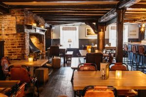 a restaurant with wooden tables and chairs and a brick wall at The Bull in Ditchling