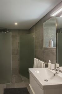 un bagno con lavandino e doccia di Casas d'Oliva a Caramulo
