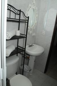 a bathroom with a sink and a toilet and a mirror at Hotel Posada Doña Rubino in Mazatlán