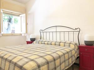 a bedroom with a bed with a plaid blanket and a window at Oasi del Pescatore in Marina di Cecina