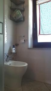 a bathroom with a white sink and a window at appartamento La Palma in Posada