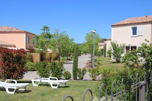 a park with white picnic tables in the grass at CHEZ BRUNO et BENEDICTE - RESIDENCE DU VENTOUX in Aubignan