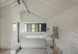 Camera bianca con divano bianco e finestre di Casas d'Oliva a Caramulo