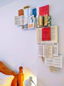 a bulletin board with books on a wall at Casa Azul in Óbidos