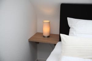 a candle on a night stand next to a bed at Moderne 2 Zimmer Wohnung in Leinfelden in hervorragender Lage und Infrastruktur in Leinfelden-Echterdingen