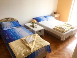 a bedroom with two beds and a vase of flowers at Apartman Centar in Trebinje