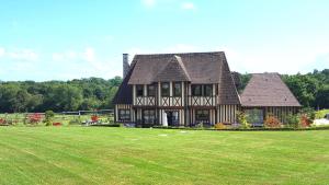 a large house with a large grass field at L'Herbe aux Vaches in Saint-Pierre-Azif