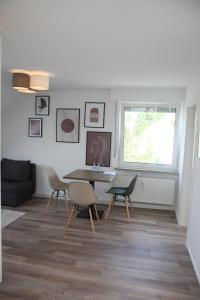 a living room with a table and chairs at Moderne 2 Zimmer Wohnung in Leinfelden in hervorragender Lage und Infrastruktur in Leinfelden-Echterdingen