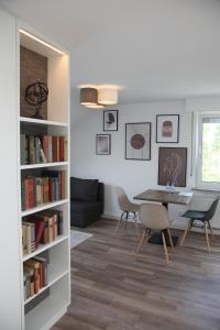 a living room with a table and chairs and a book shelf at Moderne 2 Zimmer Wohnung in Leinfelden in hervorragender Lage und Infrastruktur in Leinfelden-Echterdingen