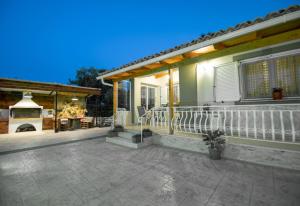 a house with a porch with a fireplace and a patio at Private Villa Bella Luna in Zakynthos