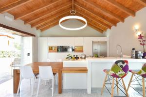 cocina con mesa de madera y sillas blancas en Villa Allureh Emblematic Lodging, en Santa Lucía