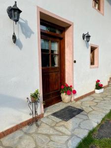 a house with a door and two potted plants on the porch at Dolomites Charme Chalet in Colle Santa Lucia
