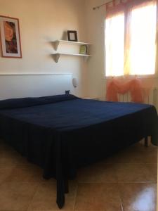 a bedroom with a bed with a blue blanket on it at Panoramica del Porticciolo in Rio Marina