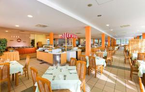 a restaurant with tables and chairs and a bar at Apartments Katoro Plava Laguna in Umag