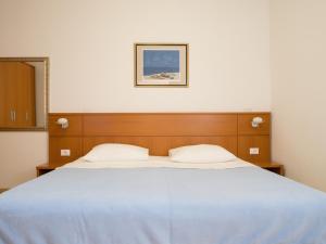 a bedroom with a large bed with a blue blanket at Apartments Luketina in Tučepi