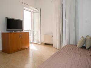 a bedroom with a bed and a television on a cabinet at Apartments Luketina in Tučepi