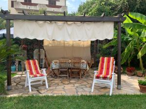 un patio con mesa y sillas bajo un dosel en Panoramica del Porticciolo, en Rio Marina