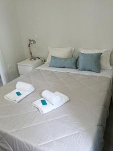 a large white bed with towels on top of it at Vivenda Mendes 2 in Vila Nova de Famalicão