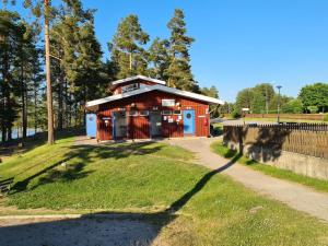 un pequeño edificio rojo en una colina con césped en Ljusdals Camping, en Ljusdal