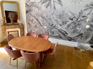 ein Esszimmer mit einem Holztisch und Stühlen in der Unterkunft La Villégiature et la Maisonnette in Vichy