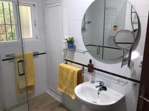 uma casa de banho com um lavatório e um espelho em Chalet con Piscina - LAS ADELFAS em Chiclana de la Frontera