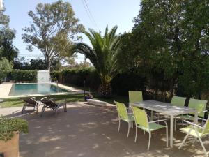 um pátio com uma mesa e cadeiras ao lado de uma piscina em Chalet con Piscina - LAS ADELFAS em Chiclana de la Frontera