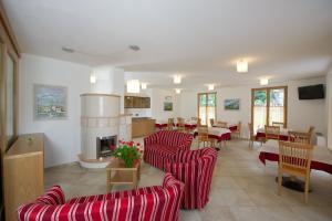 a restaurant with red chairs and tables and a fireplace at Agritur Ai Masi in Pergolese