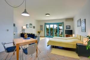 1 dormitorio con 1 cama, mesa y sillas en Apartments Villa Ana, en Medulin