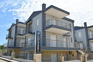 a building with balconies and a sign in front of it at Colibri in Kallithea Halkidikis