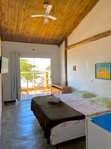 a bedroom with a bed and a ceiling fan at Chales Marissol in Ubatuba +34 photos