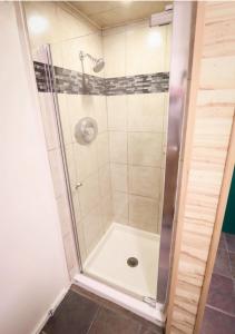 a shower with a glass door in a bathroom at Banff's Enchanted Forest Basement Suite in Banff