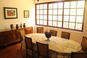 Hostal La Encantada في مدينة ميكسيكو: غرفة طعام مع طاولة وكراسي ونافذة