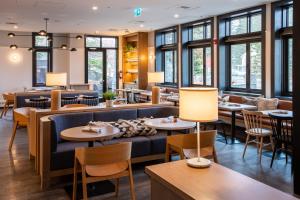 un restaurante con mesas, sillas y ventanas en Elk + Avenue Hotel, en Banff