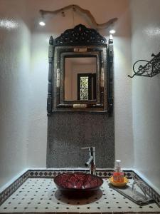 a bathroom with a sink and a mirror at Au Bord de l'Eau in Setti Fatma